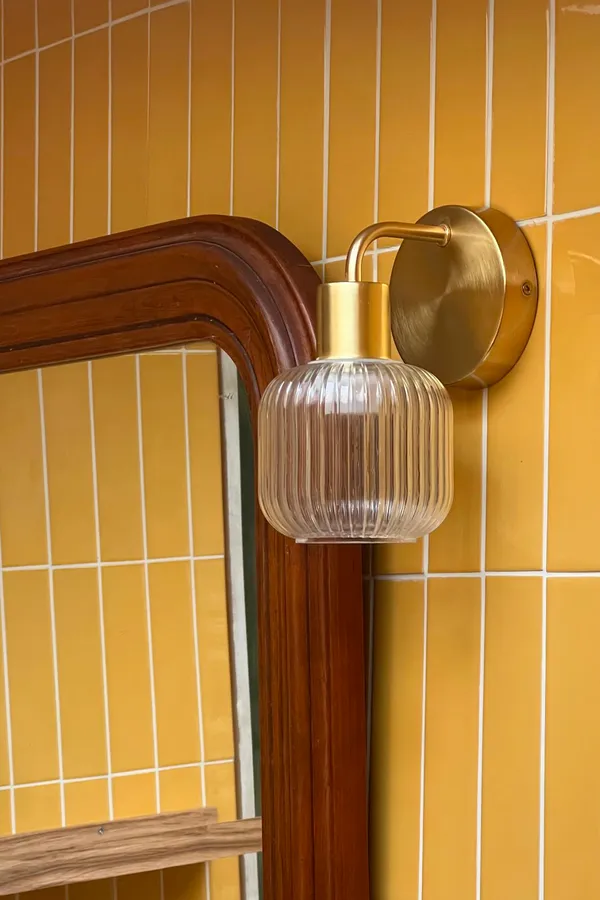 Applique murale vintage en laiton sur carrelage jaune moutarde pour une salle de bain à Concarneau