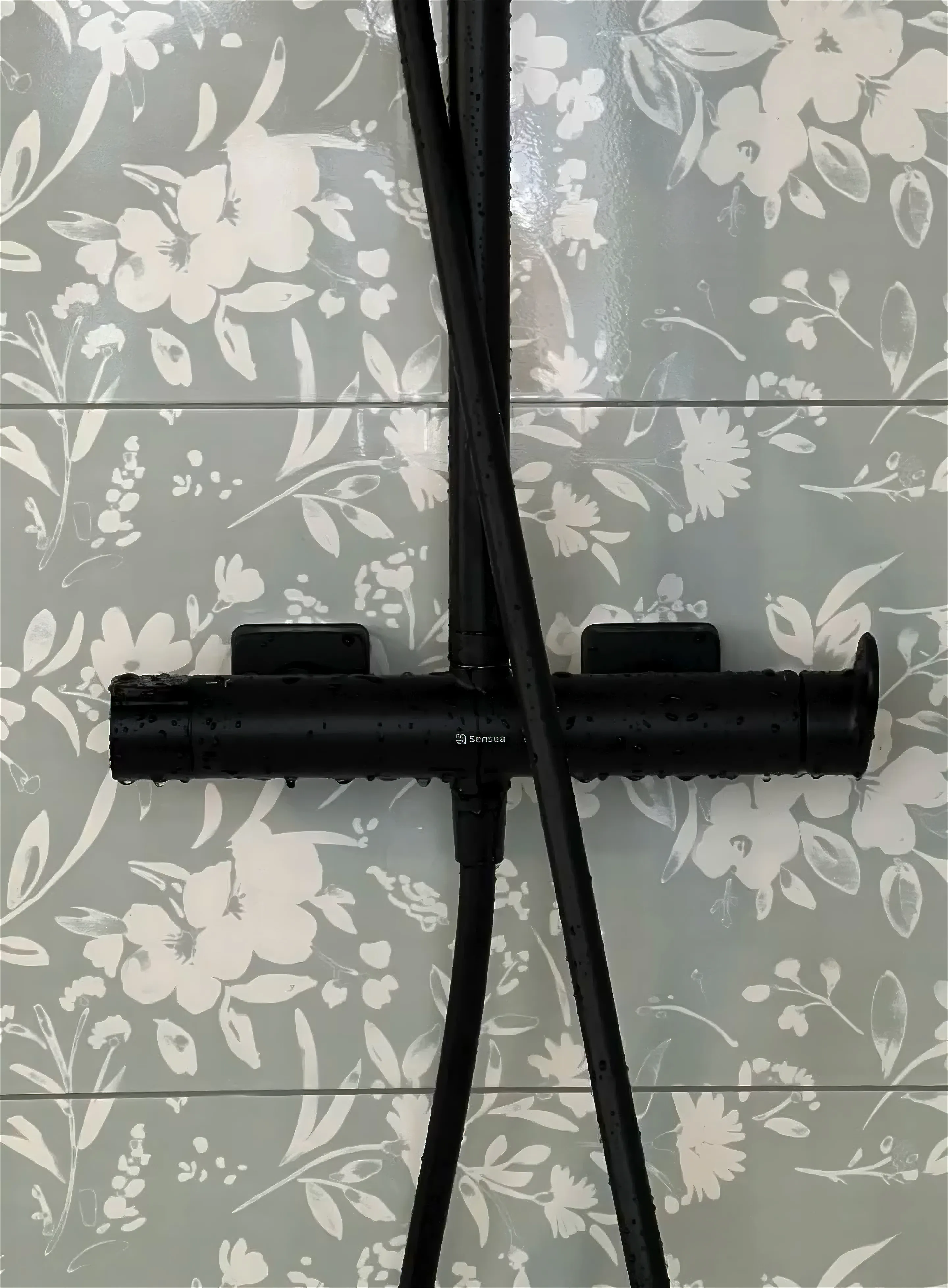 Robinetterie de douche noire mate sur carrelage à motifs floraux pour une salle de bain à Concarneau