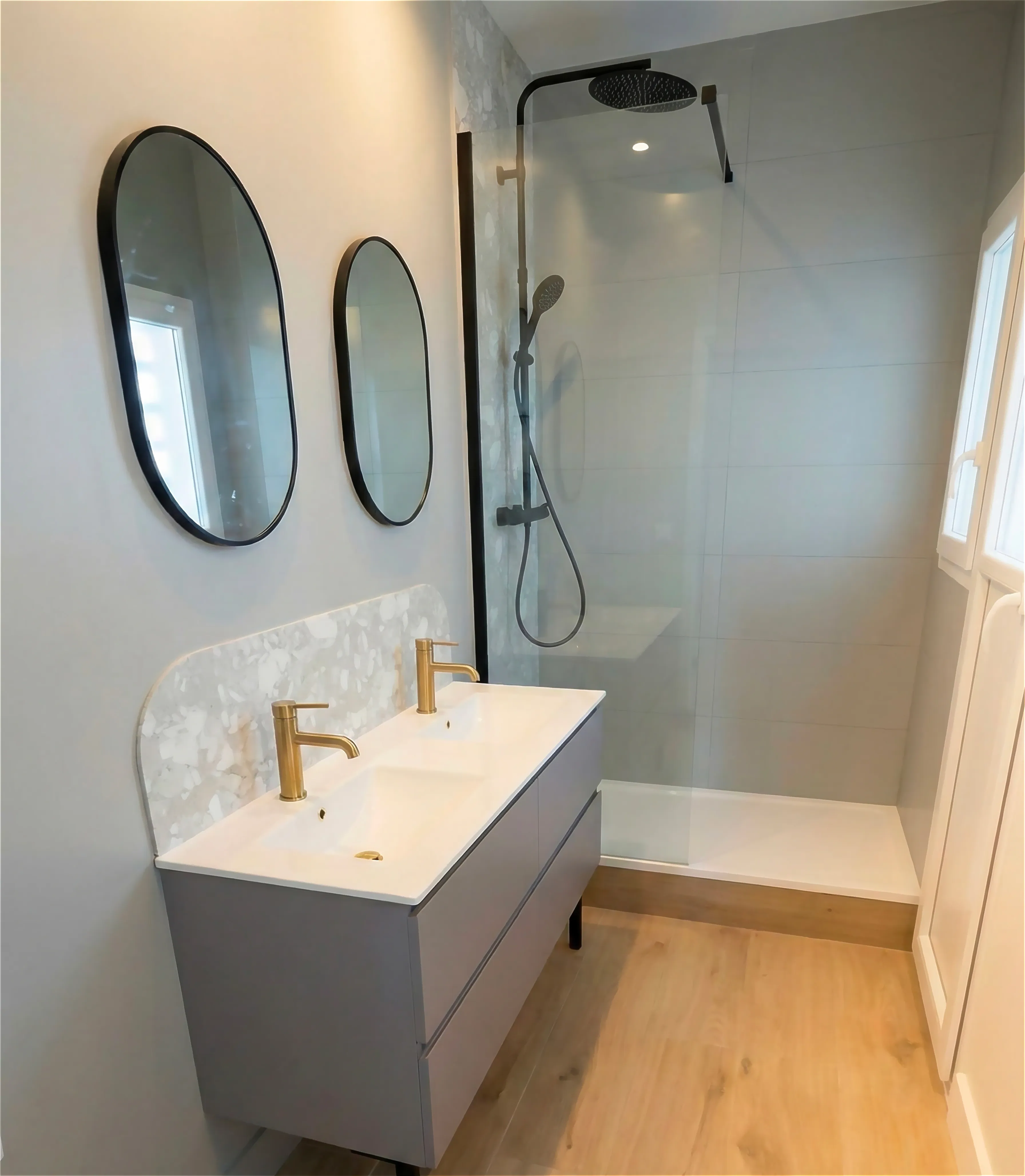 Rénovation de salle de bain à Concarneau avec meuble double vasque, robinetterie dorée et douche à l'italienne