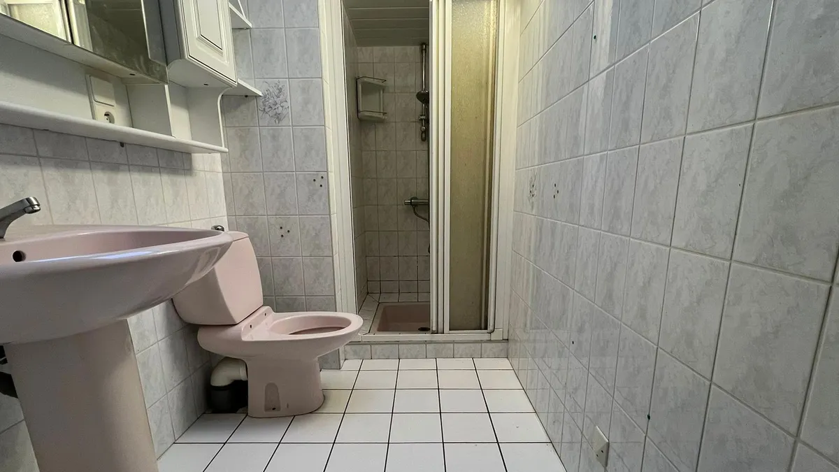 Ancienne salle de bain avec sanitaires roses avant rénovation complète à Concarneau