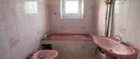 Ancienne salle de bain avec baignoire et bidet roses avant rénovation complète à Quimper
